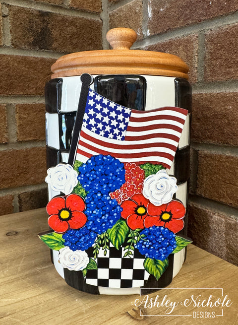 Decorative jar with American flag and floral design on a wooden surface.