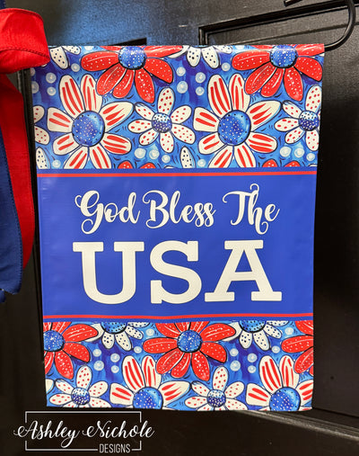 Sunbeams shining through a decorative patriotic garden flag.