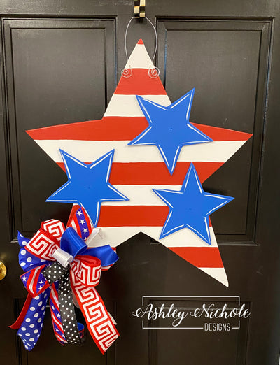 Front door decorated with a stars and stripes door hanger.